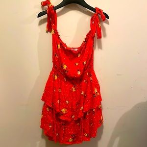 Adorable Romper in coral with floral accents and ruffled skirt.  Tie shoulders.